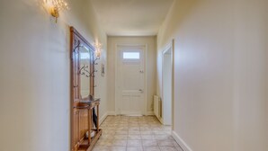 A hallway with a wooden bench, a door at the end, and a radiator on the right wall. - La Maison Sarreau Martin - Entre Vignes et Nature (Gardegan-et-Tourtirac)
