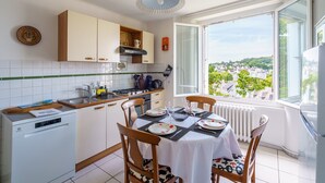 Una cocina con comedor, vistas a la ciudad y un ventanal.