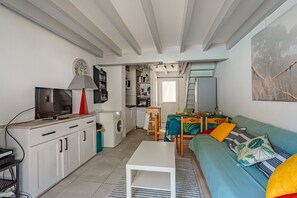 Ein gemütlicher Wohnbereich mit Küchenzeile, Essplatz und einer Sofaecke mit Kissen.