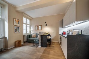 Eine moderne Küche mit Essbereich, einer Couch und Kunstwerken an den Wänden.