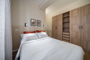 Ein Schlafzimmer mit einem Bett, einem Kleiderschrank und zwei Wandleuchten.
