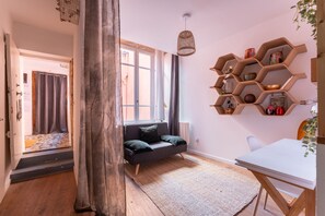 Ein modernes Wohnzimmer mit einer Couch, einem weißen Tisch und einem Holzregal mit Dekoration.