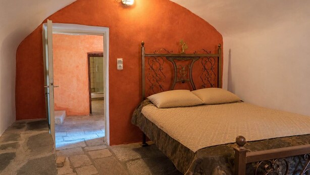 Un dormitorio con una cama, un arco de entrada y una lámpara.