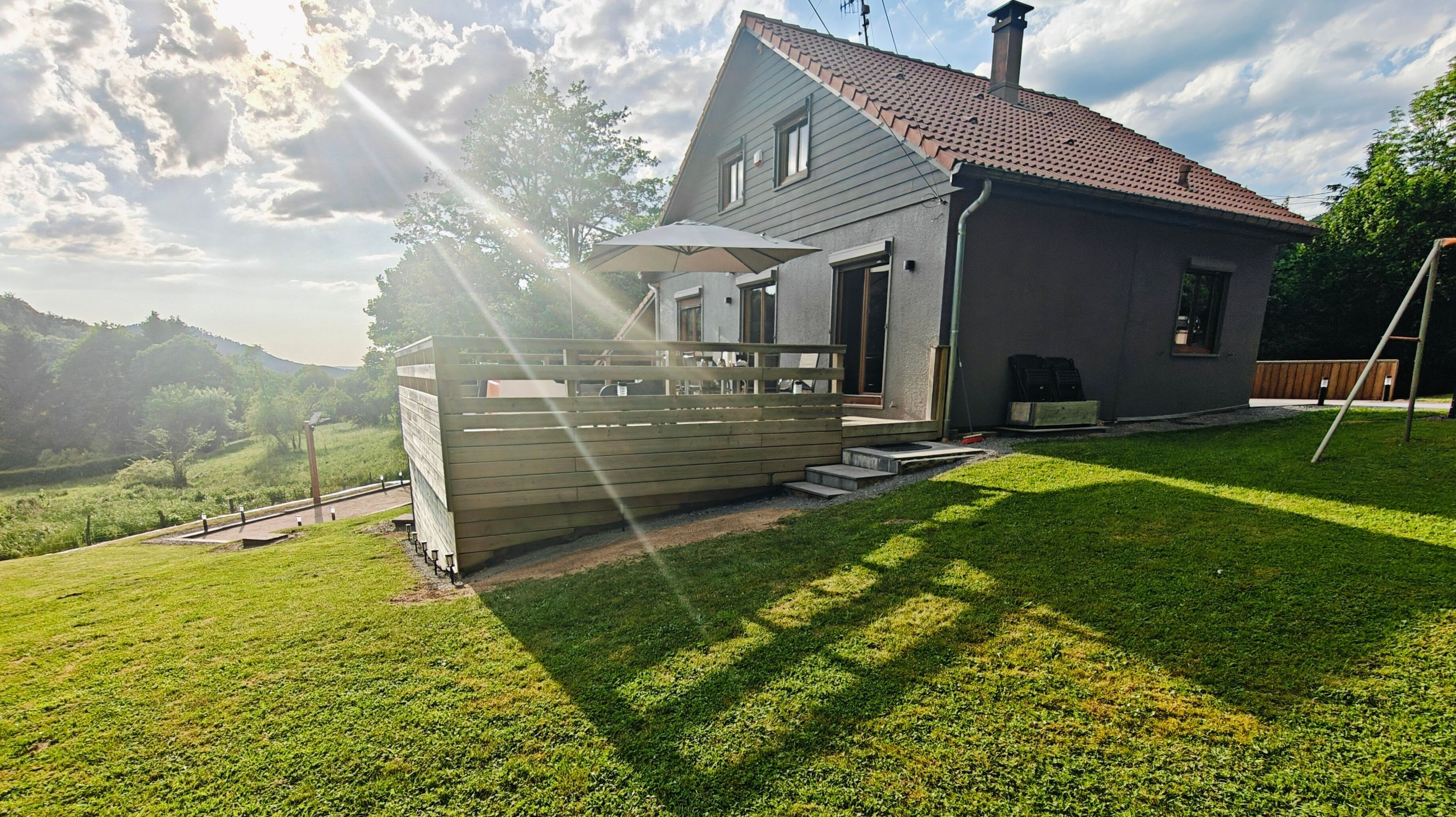 A house with a sloped roof, a front porch, and a fenced yard.