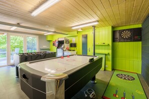 A pool table with a dartboard and foosball table in a brightly lit room with green walls. - La Boule - Joli chalet pour 9 avec un grand jardin (Vienville)