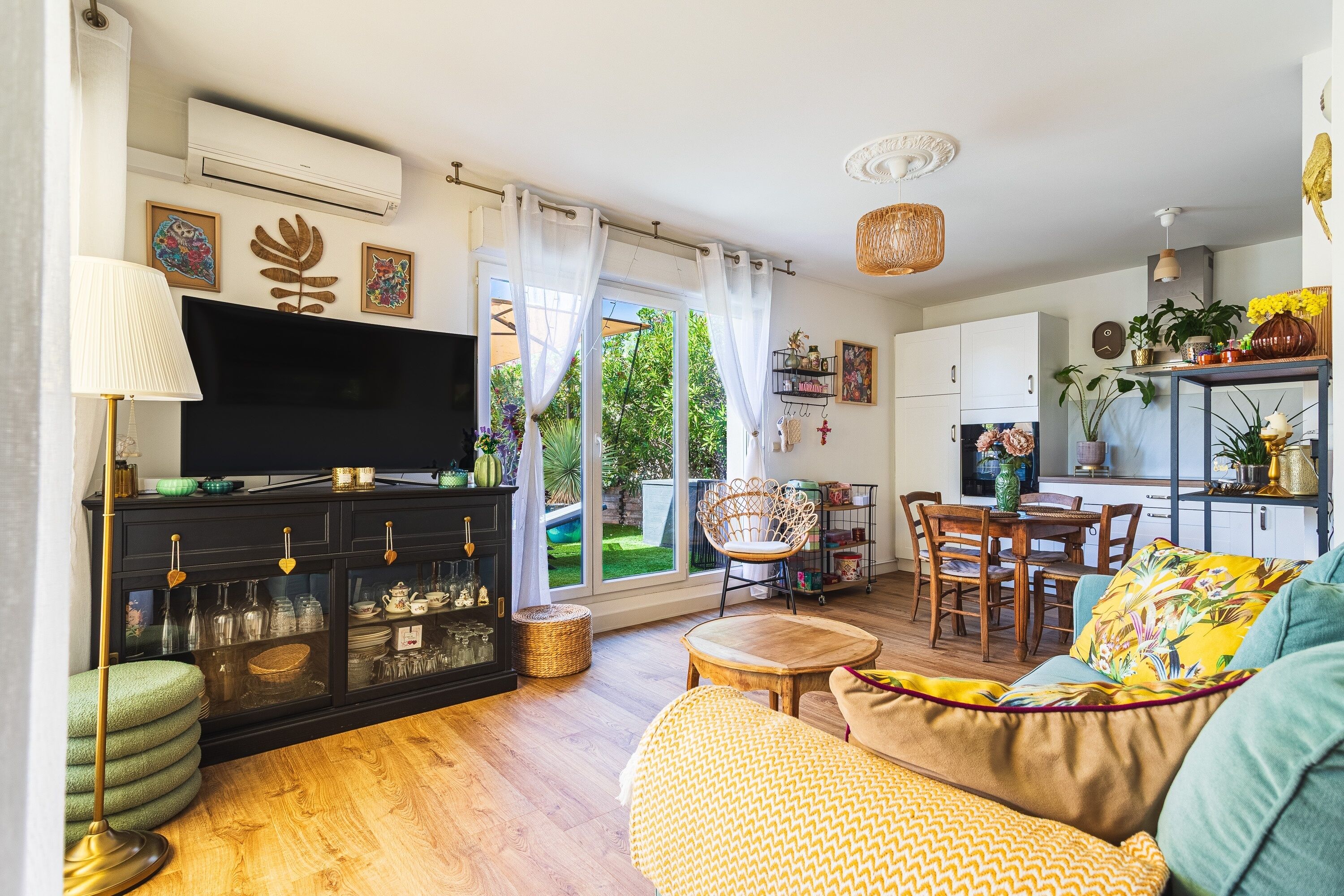 A living room with a TV, sofa, and dining area.