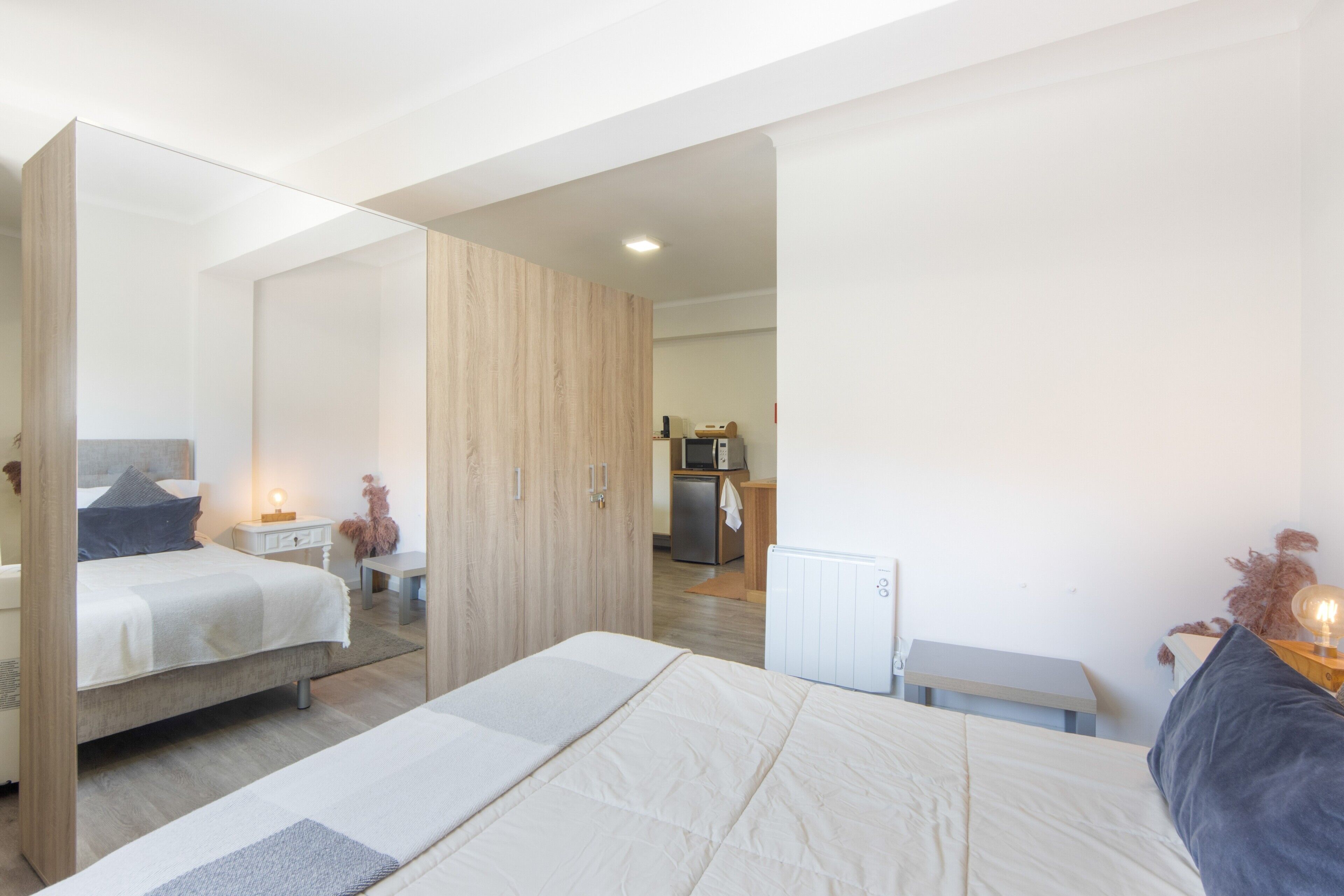 Une chambre à coucher moderne avec un grand lit, une table de chevet et une armoire.