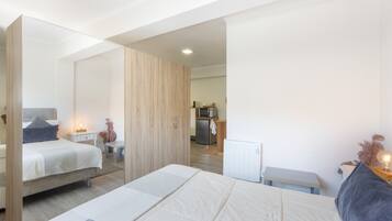Une chambre à coucher moderne avec un grand lit, une table de chevet et une armoire.