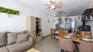 Una cocina moderna con comedor, muebles de madera y un ventilador de techo.