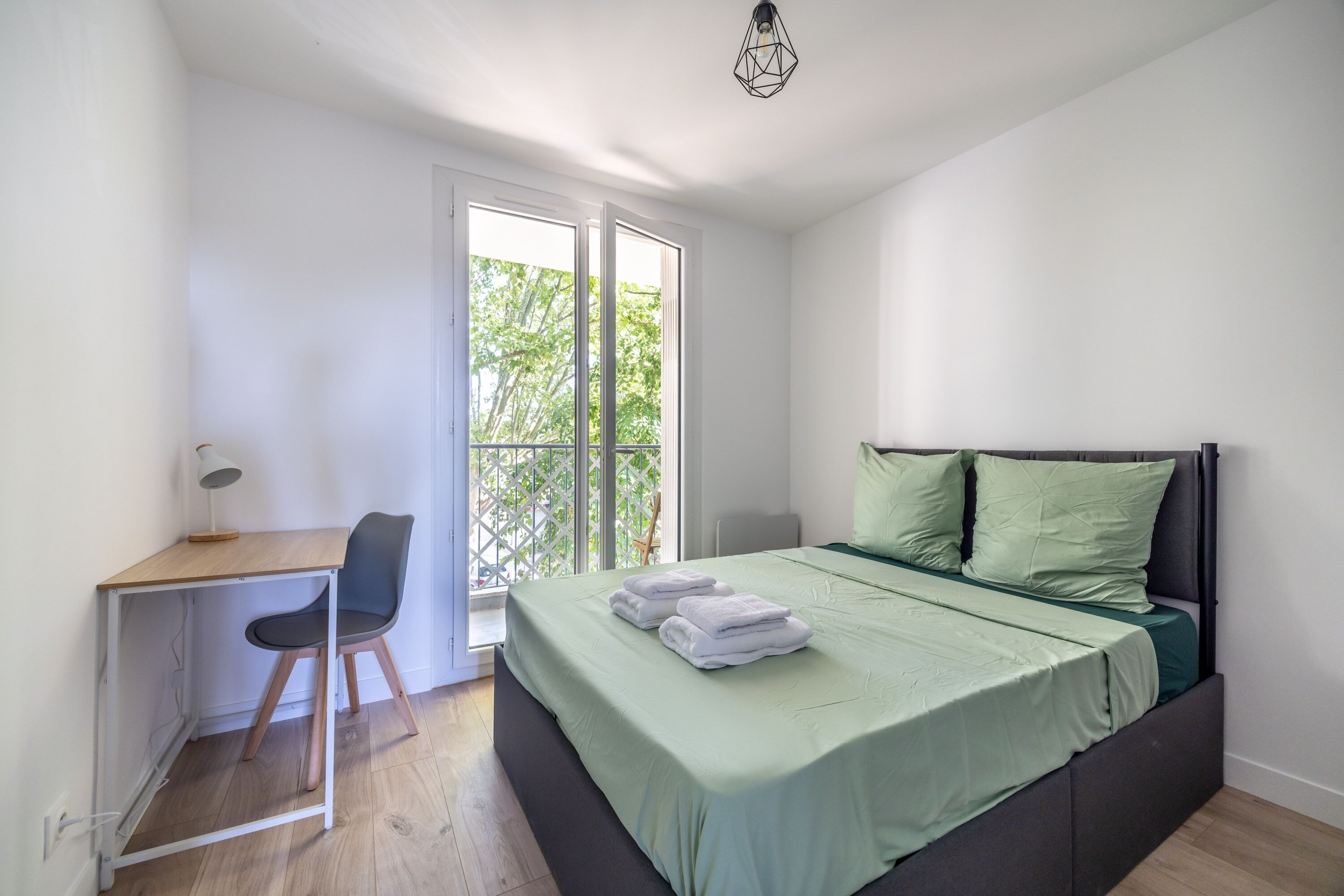Un dormitorio con cama, escritorio y silla.