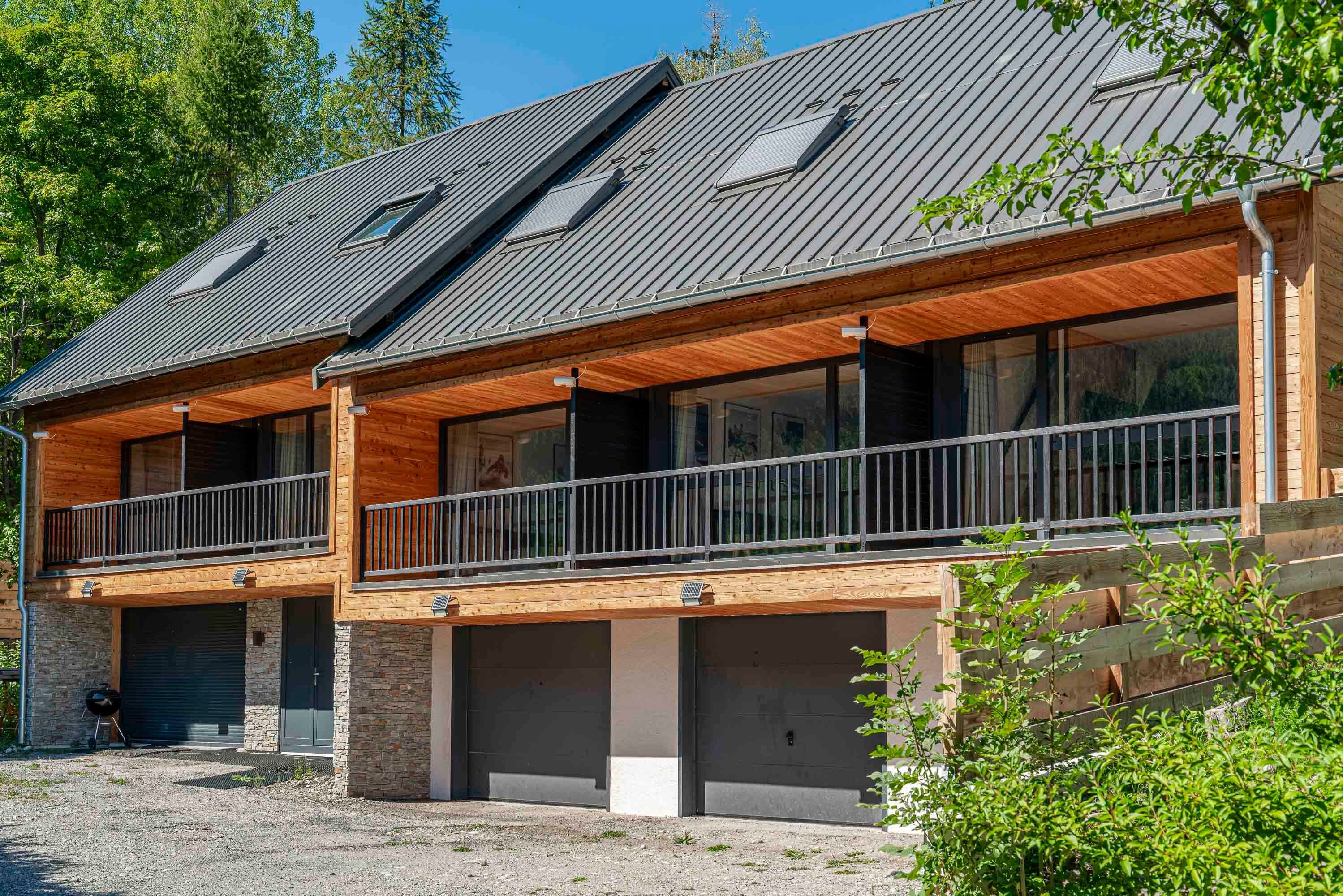 Un edificio a due piani con facciata in legno, ampie finestre e un balcone.