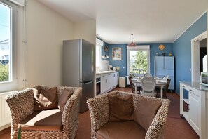 Une cuisine de taille réduite, équipée d’un réfrigérateur, d’une table à manger et de chaises.