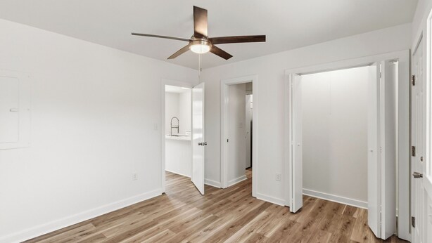 A hallway with wooden flooring, white walls, and a ceiling fan. - Cozy 1-Bedroom Condo minutes from the Beach, Kill Devil Hills with AC (Kill Devil Hills)