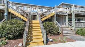 A wooden staircase leading to a building with multiple levels, marked with numbers 2, 3, 6, and 7. - Cozy 1-Bedroom Condo minutes from the Beach, Kill Devil Hills with AC (Kill Devil Hills)