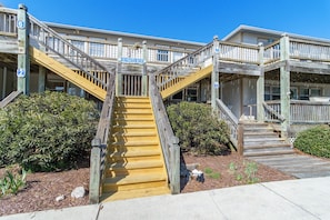 A wooden staircase leading to a building with multiple levels, marked with numbers 2, 3, 6, and 7. - Cozy 1-Bedroom Condo minutes from the Beach, Kill Devil Hills with AC (Kill Devil Hills)