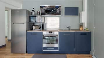 Een moderne keuken met een inbouwoven, een magnetron en een koelkast.