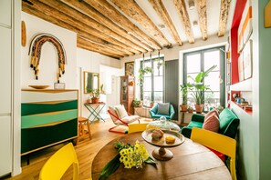 Un salón acogedor con techo de madera, muebles coloridos y plantas en macetas.
