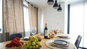 A dining table set with plates, glasses, a bottle of wine, and a bowl of grapes. - -BLOOM- TOWNHOUSE WITH GARAGE, SHARED COURTYARD (Concarneau)