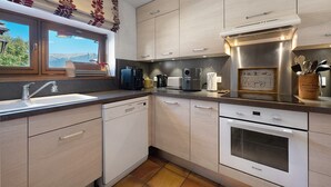 Una cocina moderna con lavavajillas integrado, estufa y ventana con vistas al exterior.