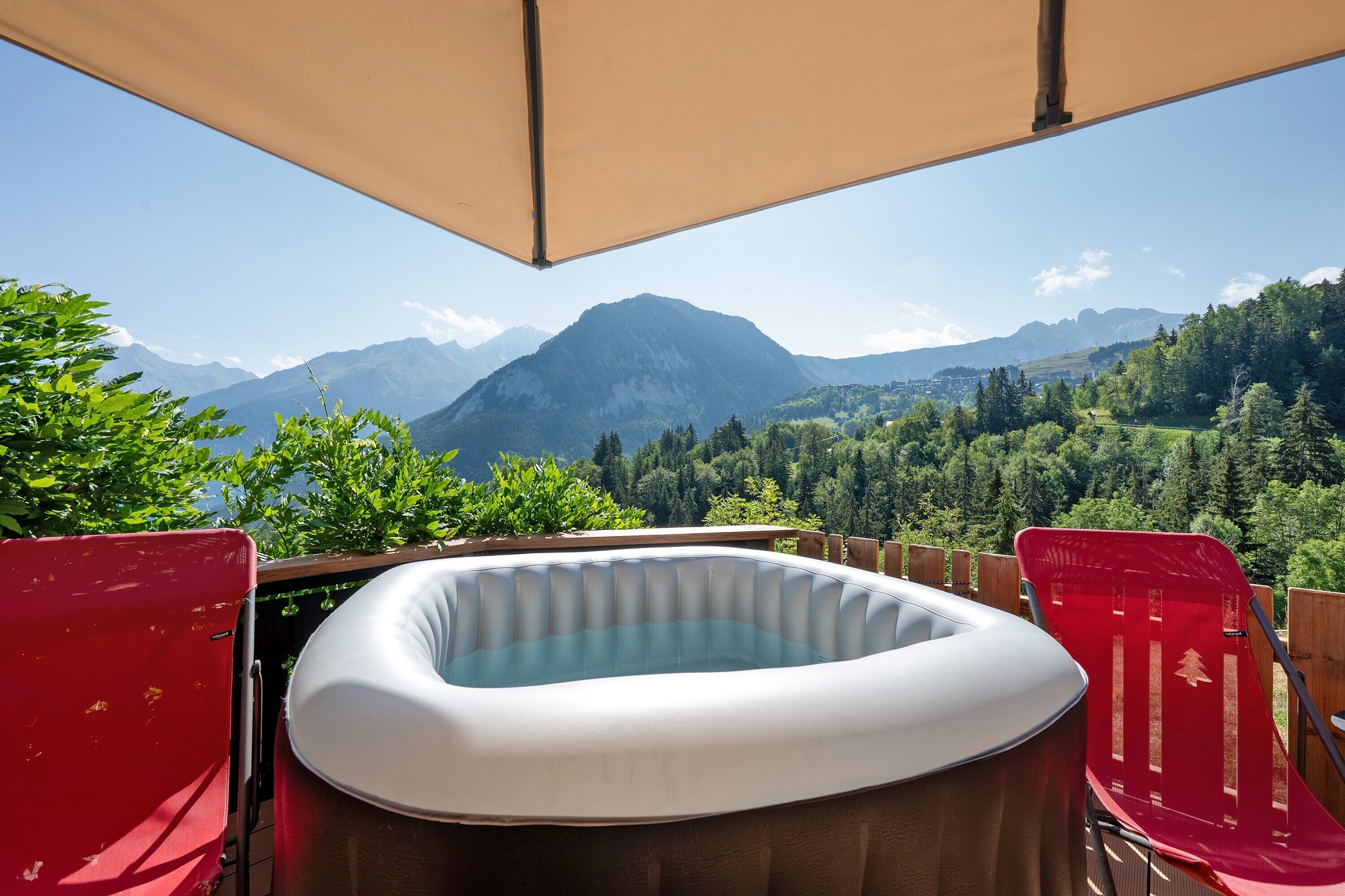 A hot tub with a view of mountains and forest.