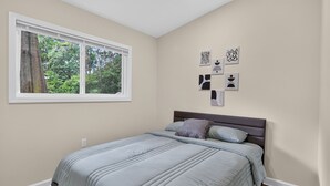Quarto com cama, janela e decoração nas paredes.