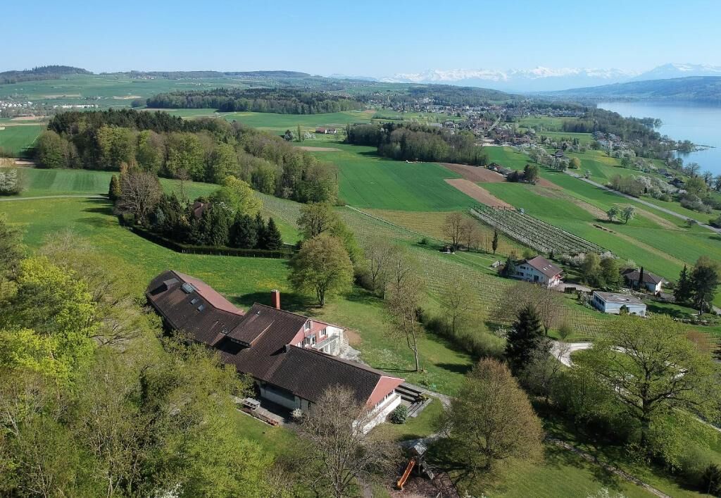 Un paysage rural avec une maison entourée de champs et d’un lac.