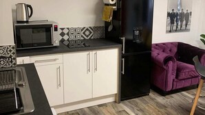 A compact kitchen with a microwave, kettle, and a black refrigerator. - Private Movie Theater in Calais • XXL Screen • Immersive sound (Calais)