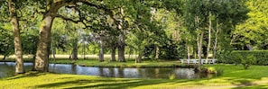 A serene park with a pond, trees, and a white bench. - Le Château de la Villedubois, une propriété d’exception proposée par laclefduchateau.com, vous accueille près de Rennes pour un séjour de charme au cœur de la Bretagne. (Mordelles)