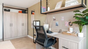 Een moderne kantoorruimte met een bureau, stoel, boekenkast en een potplant.