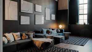 Een moderne woonkamer met een bank, salontafel en vloerkleden met een patroon.