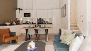 Een modern appartement met keuken, eethoek en woonkamer.