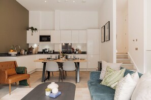 A modern apartment with a kitchen, dining area, and living room. - Student Only YourTRIBE Deptford (London)