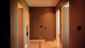 A hallway with wooden flooring and doors leading to other rooms. - Villa with Pool | San Pietro Resort (Durrës)