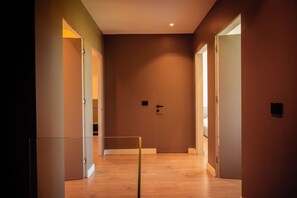 A hallway with wooden flooring and doors leading to other rooms. - Villa with Pool | San Pietro Resort (Durrës)
