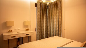 Een hotelkamer met een bed, nachtkastjes, lampen en een gordijn.