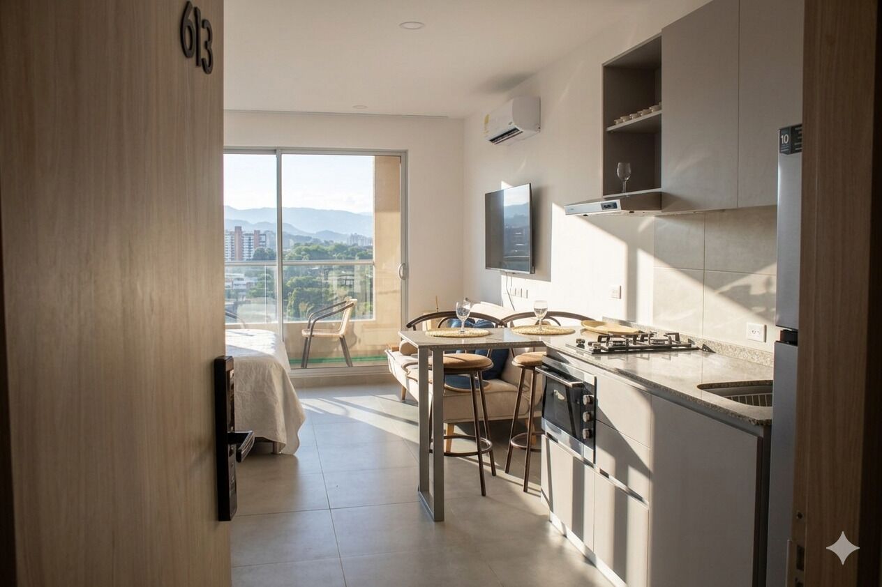 Eine moderne Küche mit Essbereich, einem über der Arbeitsplatte montierten Fernseher und einem Balkon mit Blick auf die Stadt.