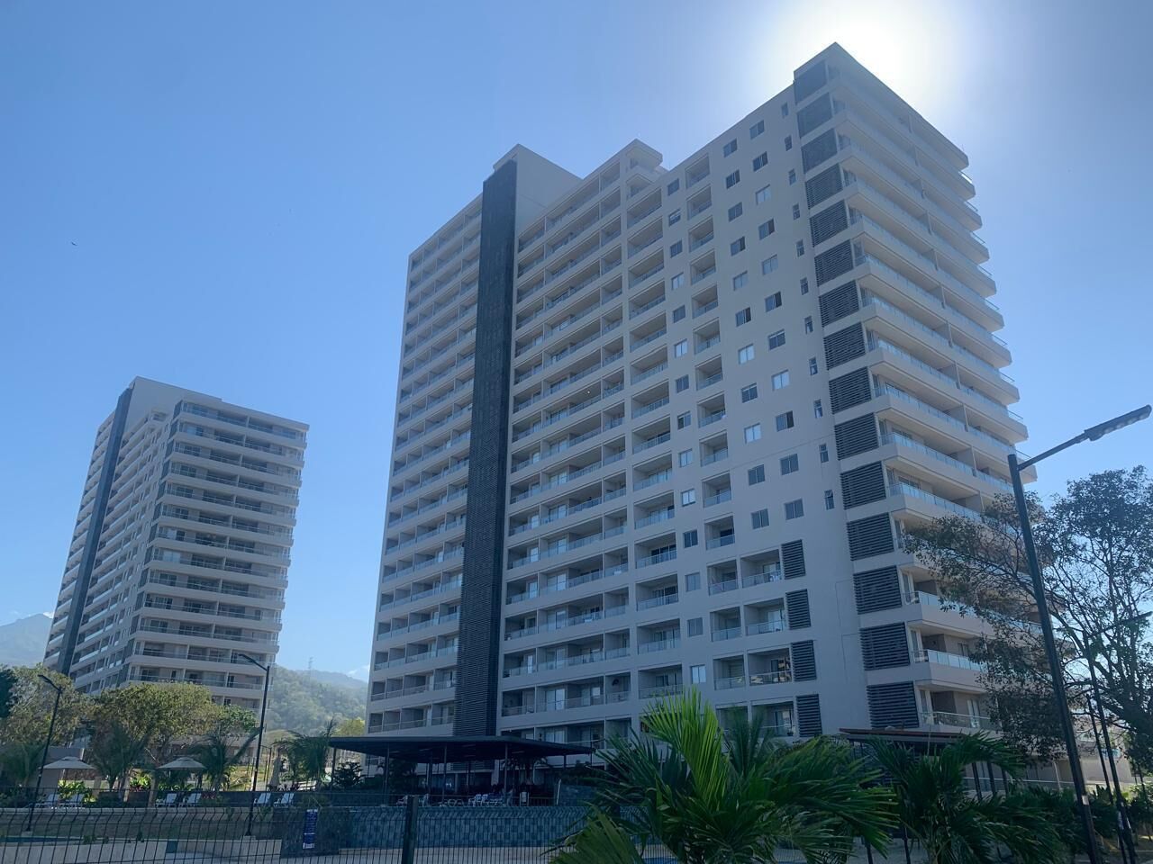 A high-rise building with multiple balconies and a clear sky.