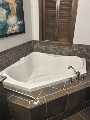Ein Badezimmer mit einer freistehenden Badewanne, einer Dusche und einem gefliesten Boden.