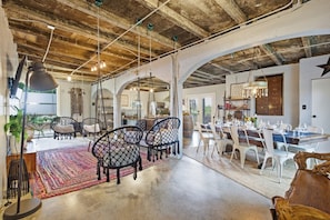 A spacious interior with a dining area, kitchen, and seating with hanging chairs. - Eclectic Asheville Escape w Fire Pit & Yard! (Asheville)