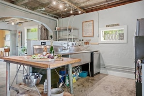 A kitchen with a large island, stainless steel appliances, and a window with a view. - Eclectic Asheville Escape w Fire Pit & Yard! (Asheville)