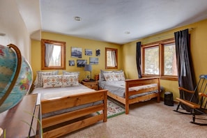 A room with two wooden beds, a globe, and a rocking chair. - 400 Whispering Pines Dr. (Blue River)