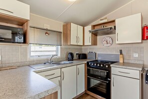 Una cocina moderna con estufa, horno y microondas integrados.