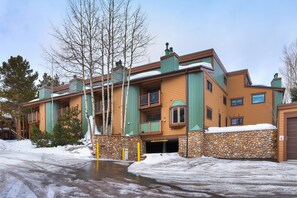 A multi-story hotel with a stone facade, balconies, and a snow-covered ground. - Sundowner II 203 in Breckenridge (Breckenridge)