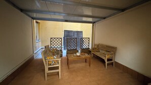 A room with a tiled floor, wooden furniture, and a window with blinds. - R&B Santa Nicolella (Catania)