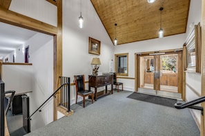 Un escalier avec des rampes en bois, un plafond en bois et un plancher recouvert de moquette.