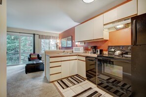 A compact kitchen with a refrigerator, stove, microwave, and a dishwasher. - Wildwood Suites 202 in Breckenridge (Breckenridge)