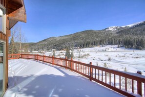 A snow-covered landscape with a wooden building and a red railing. - Evan's Mountain Lodge (Blue River)