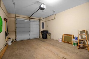 A garage with a closed garage door, a ceiling-mounted projector, and various construction materials like buckets and a ladder. - Highlander 301 in Breckenridge (Breckenridge)