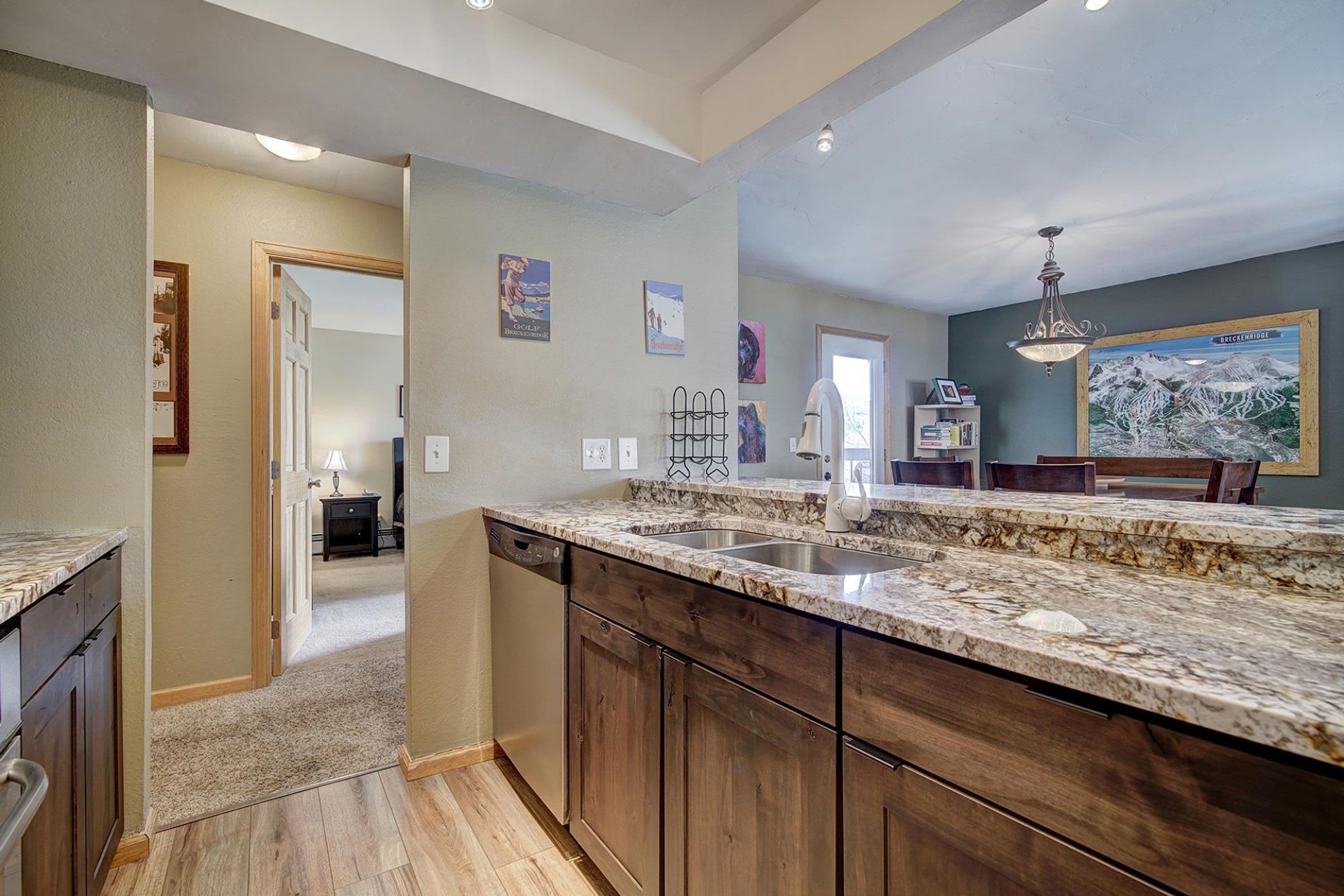 A kitchen with wooden cabinets, granite countertops, and a dishwasher.