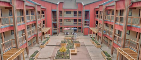 A multi-story building with balconies and a central courtyard with planters.